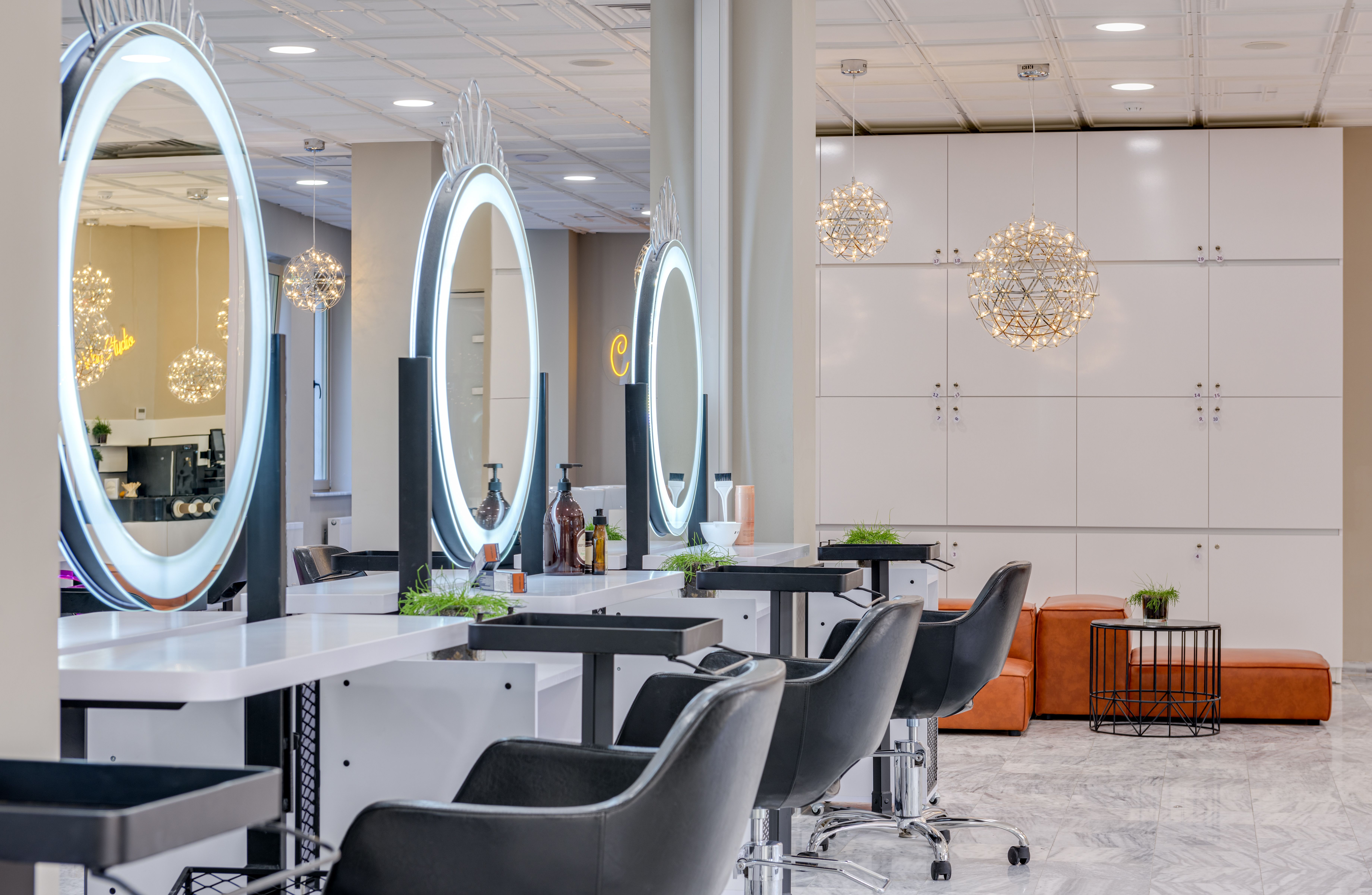A bright, modern salon interior with styling chairs and round mirrors.