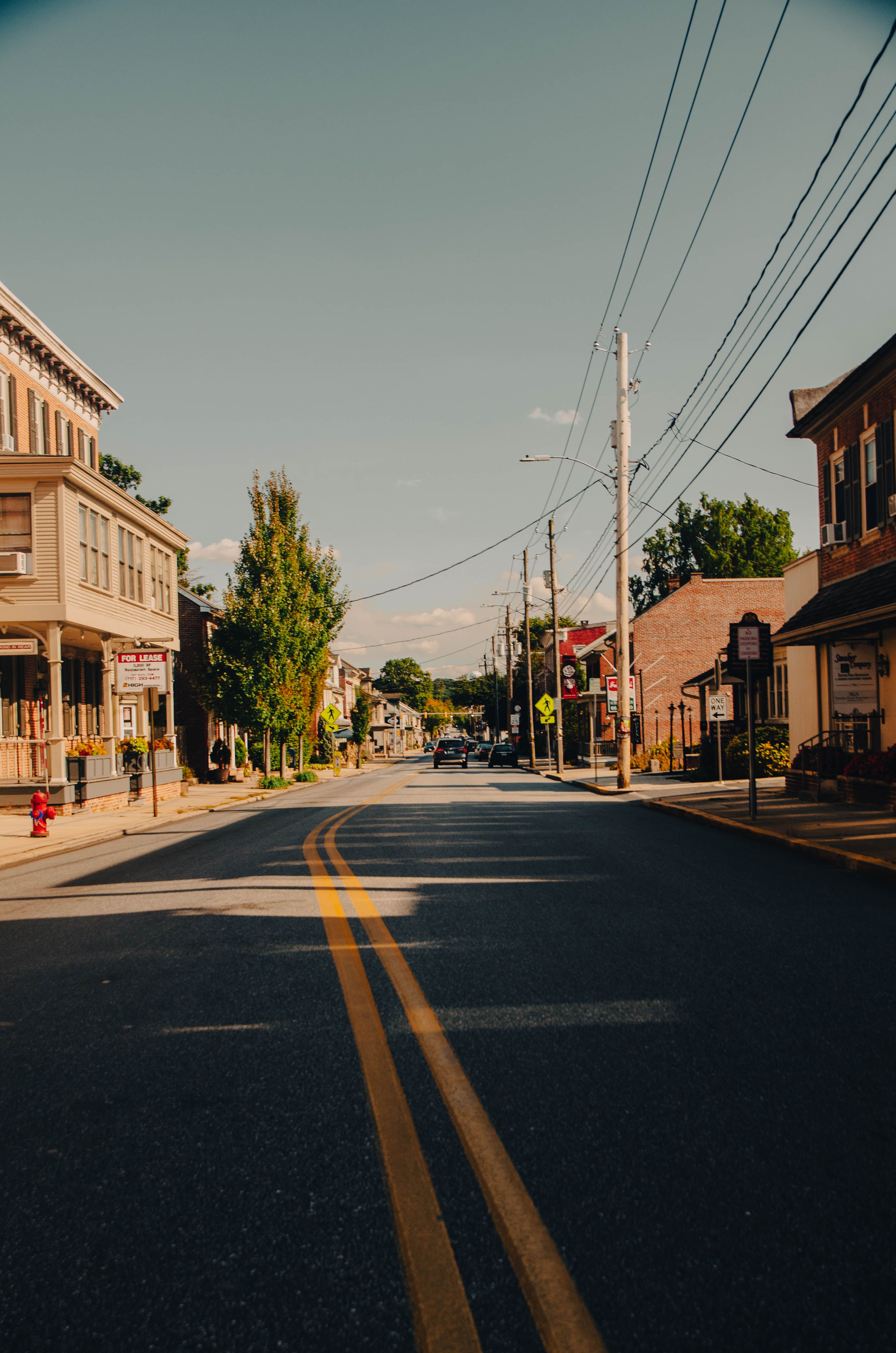 A quiet small-town Main Street lined with local storefronts, representing the close competition small businesses in dense areas like New Jersey face from neighbors just down the block.